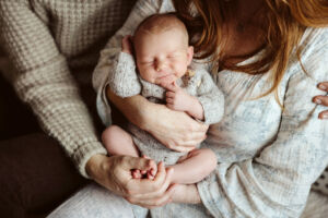 Foreldre som holder nyfødt baby på fotografering.