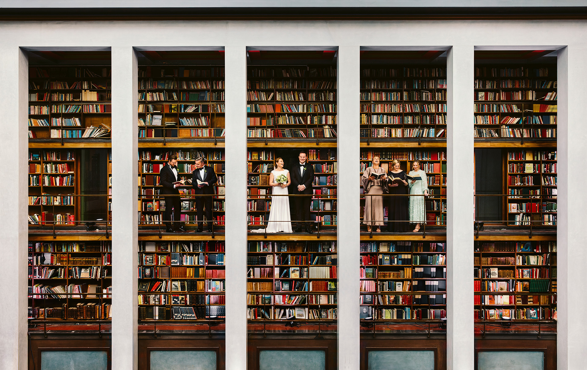 Brudepar og forlovere står i bokhyllene på Gamle Deichman bibliotek