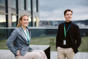 En sittene og en stående person i jobbantrekk