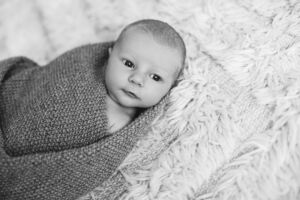 Nyfødt baby med våkent blikk. Sorthvit