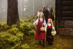 Brudepiker i festdrakt. Kaster roseblader.