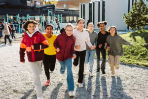 Smilende elever løper skolegården på Oslo International School