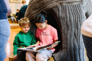 Elever på tvers av skoletrinnne leser sammen på biblioteket