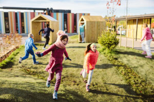 To elever løper over lekeplassen på Oslo International School